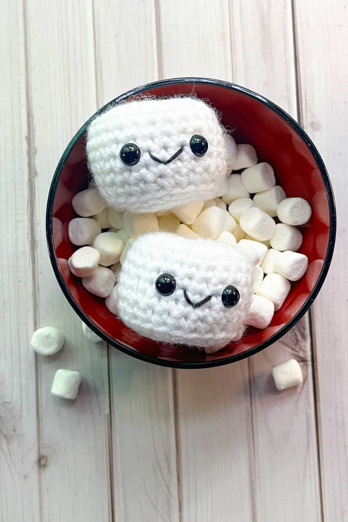 Finished crochet marshmallows in a bowl of marshmallows.