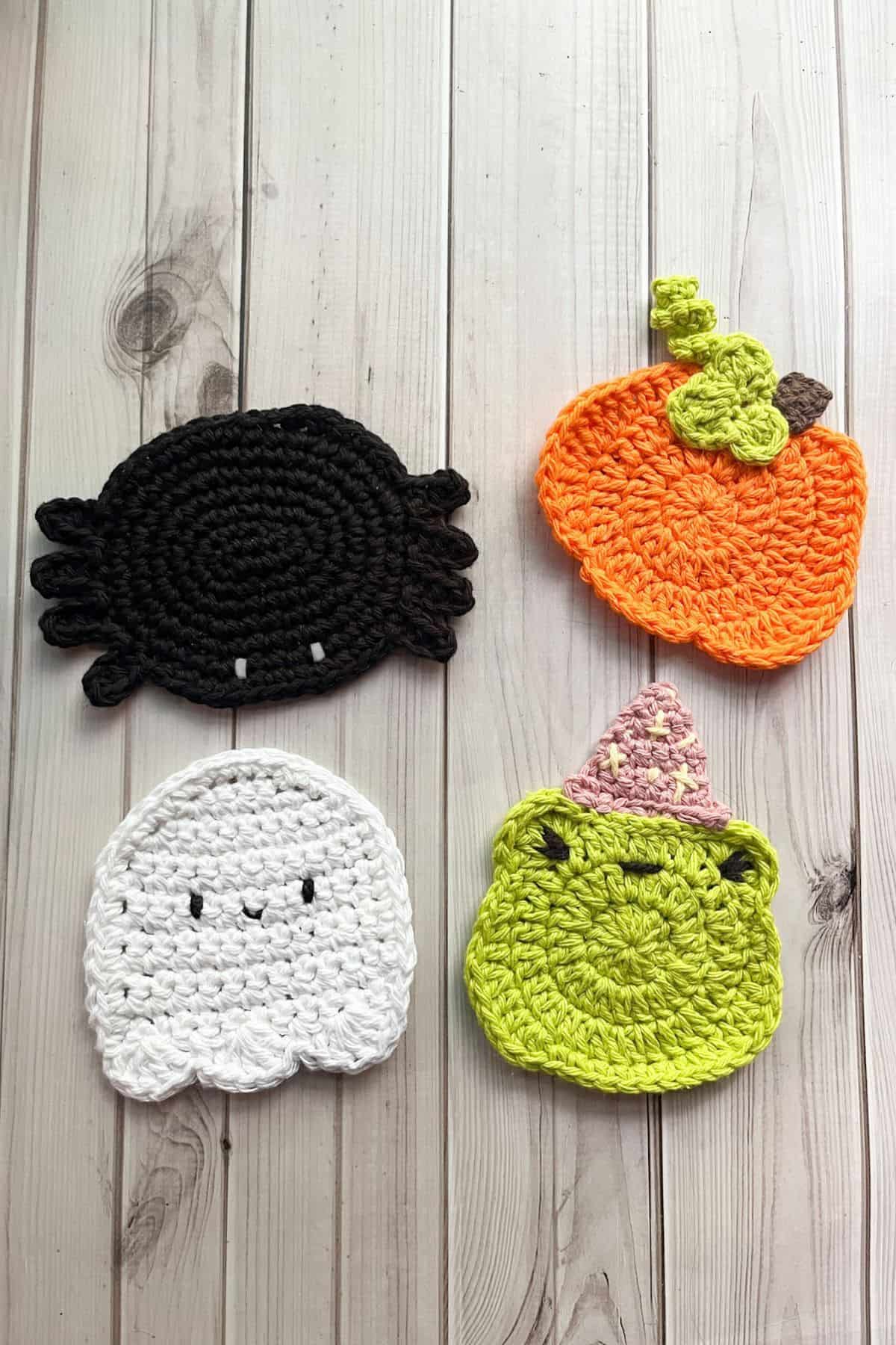 Finished crochet spider coaster with pumpkin, ghost, and wizard frog coaster.
