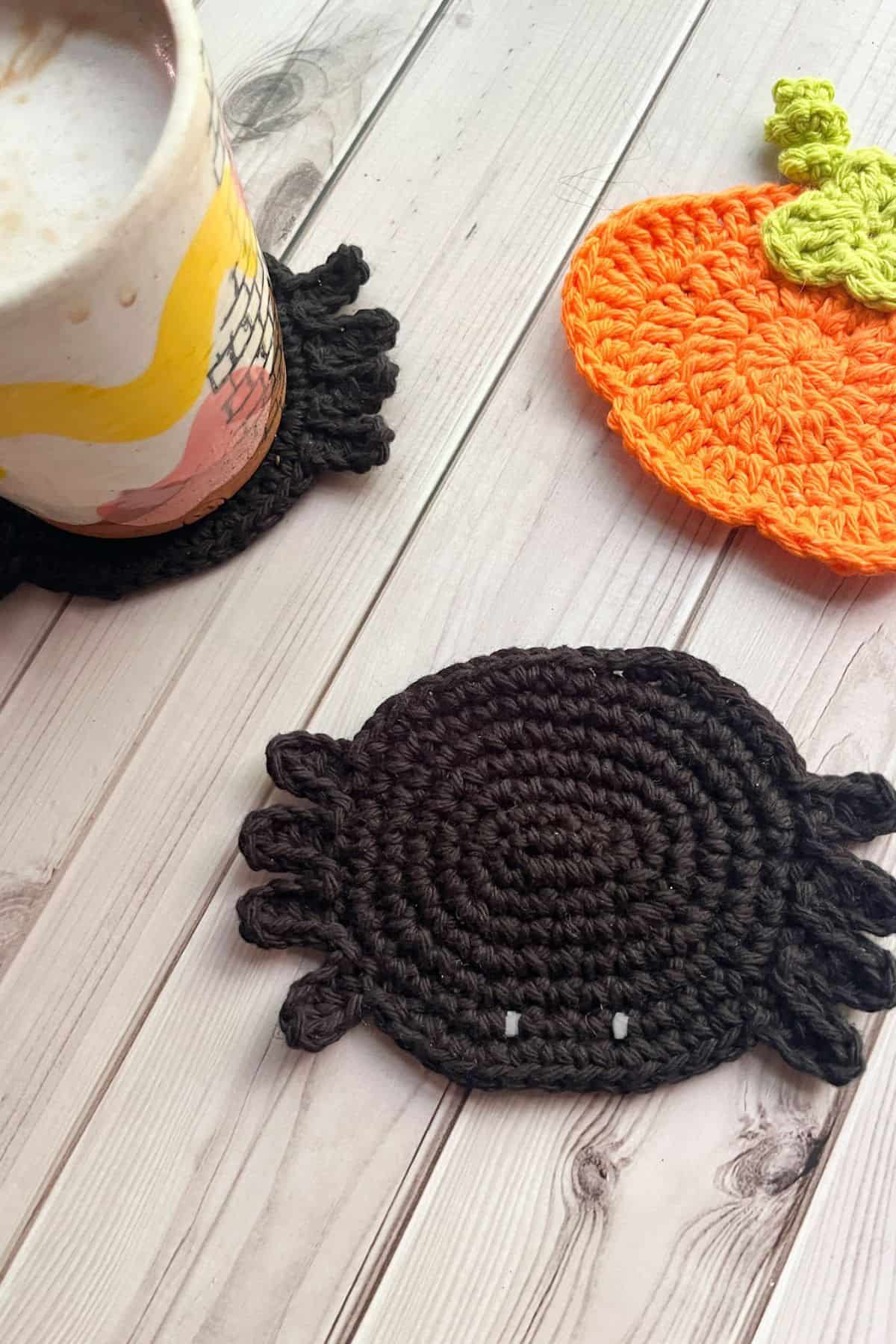 Finished crochet spider coaster with pumpkin coaster.