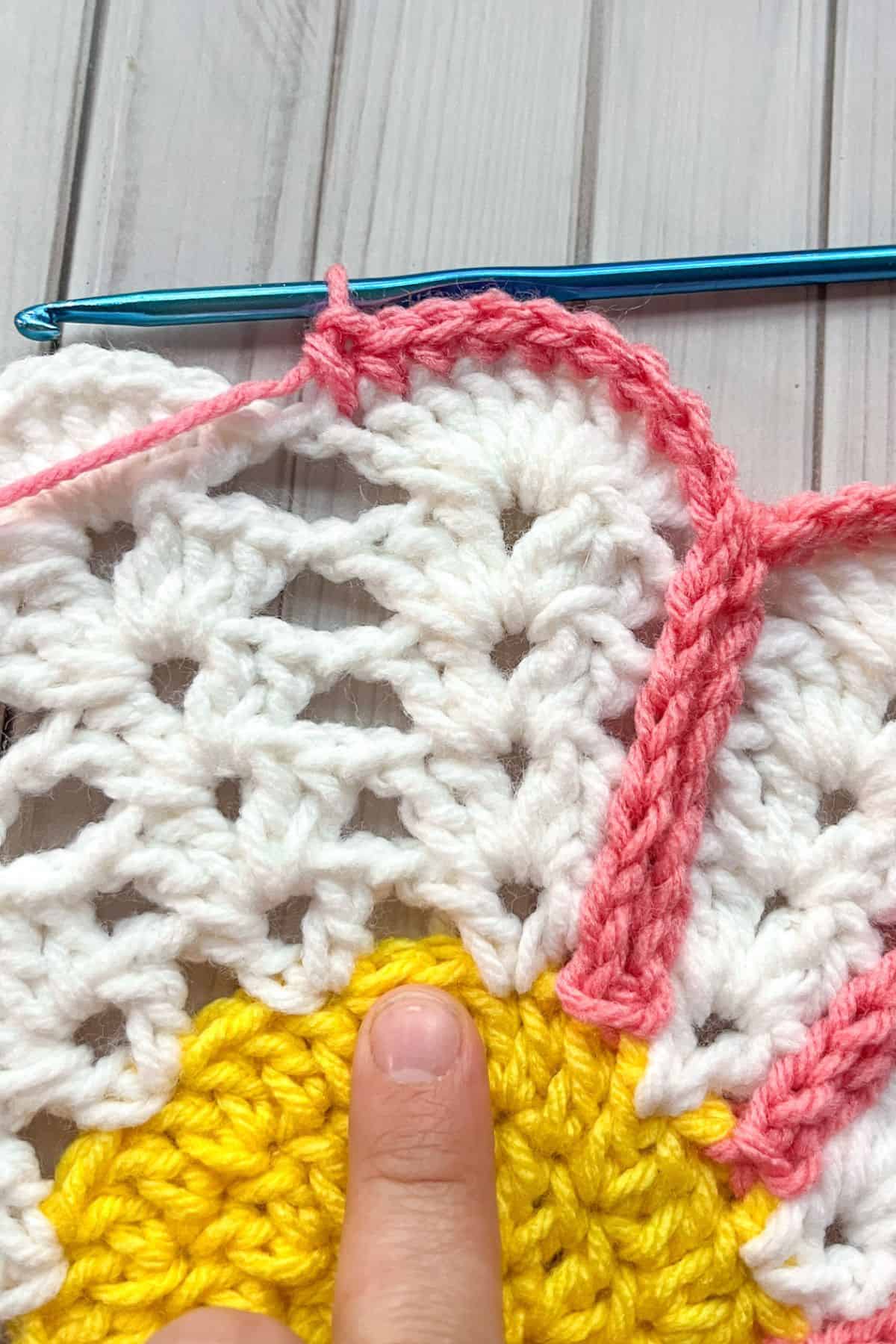 Outlining the flower petals with single crochet, slip stitches, and chains.