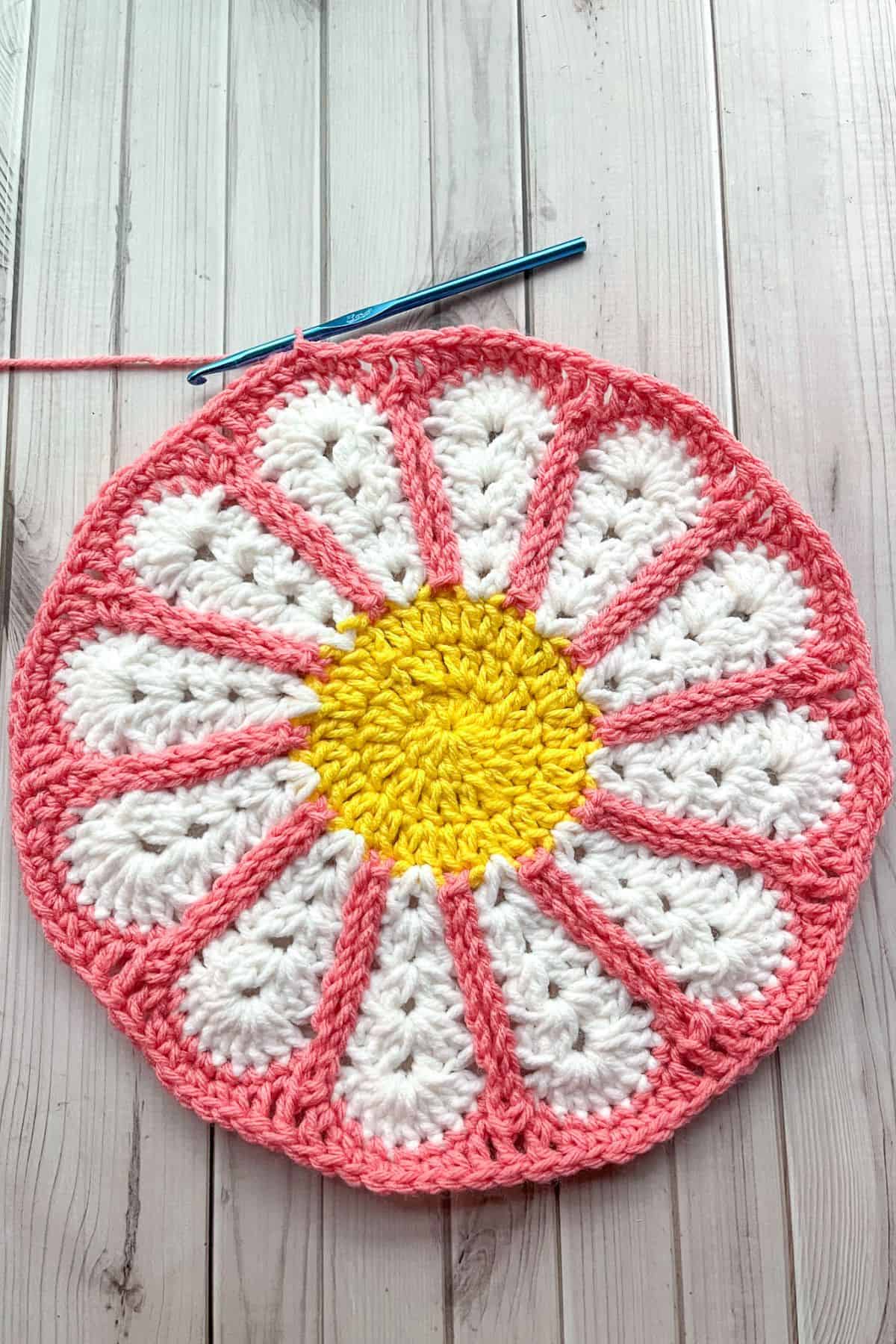 Crocheting the flower motif into a circle.