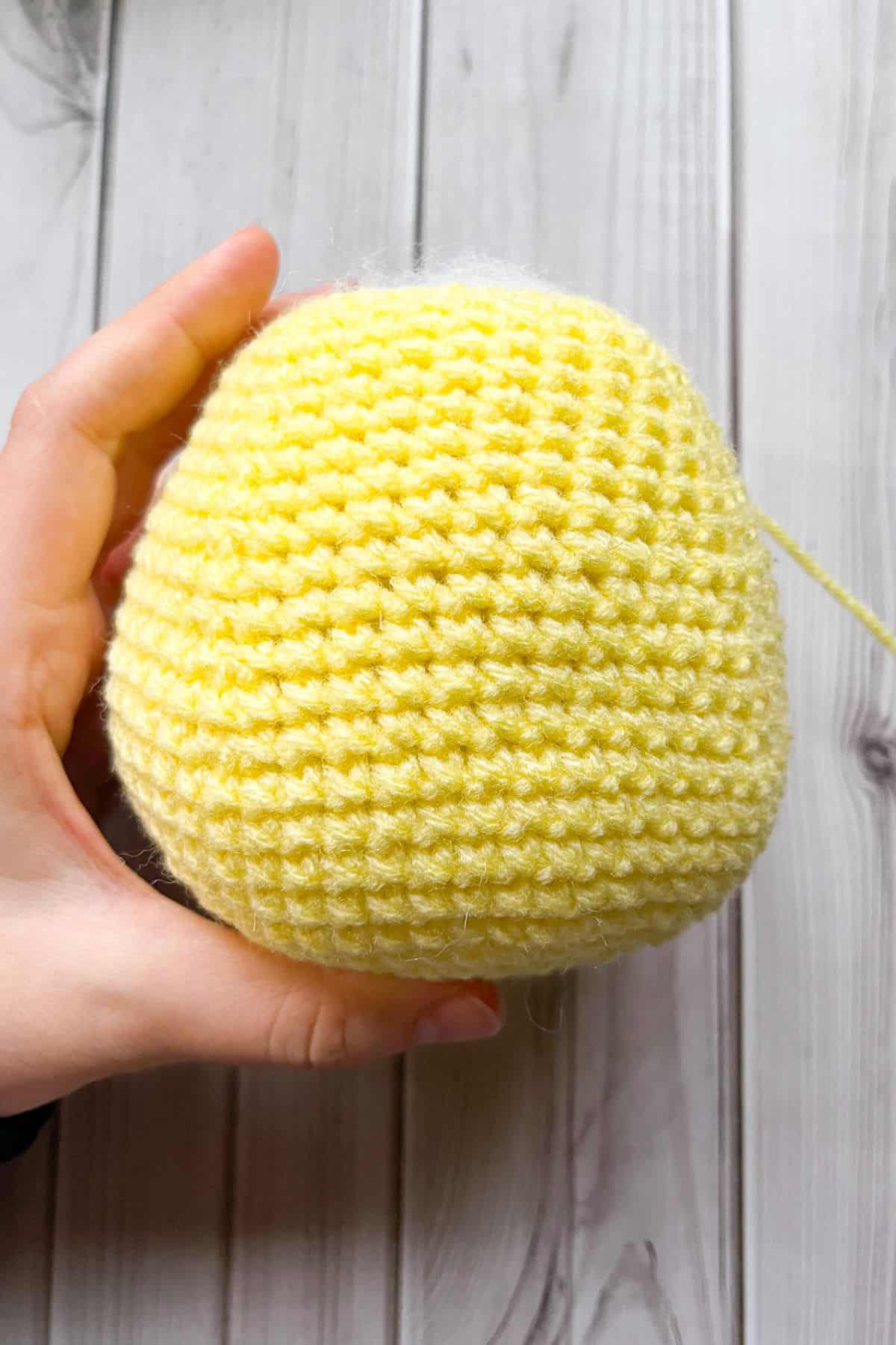 Crochet duck body on table.