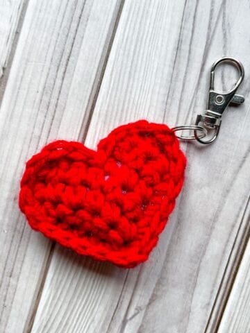 Crochet heart keychain on table.