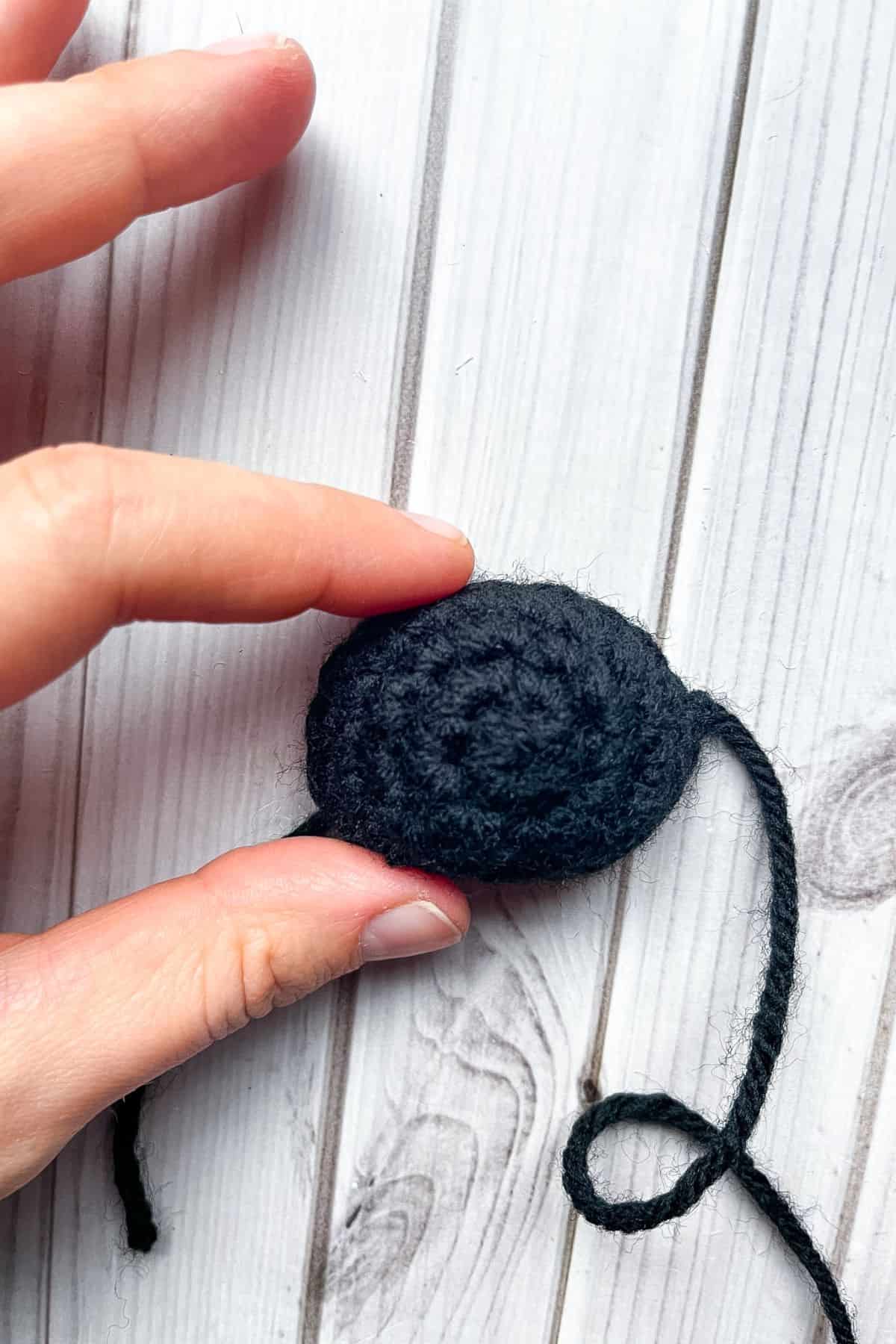Crochet ladybug face, hand for scale.