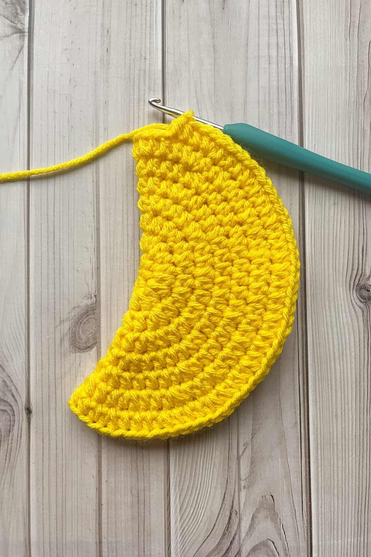 Folding the crochet rounds in half to show how it is starting to bend.