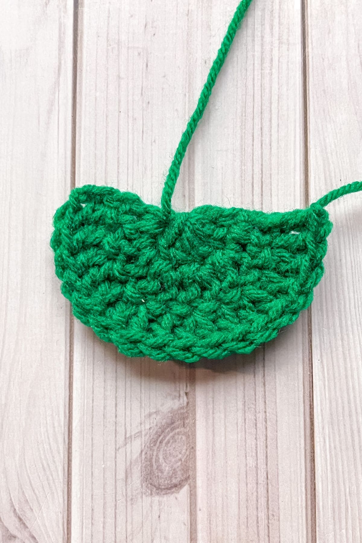Large strawberry crochet leaf on table.