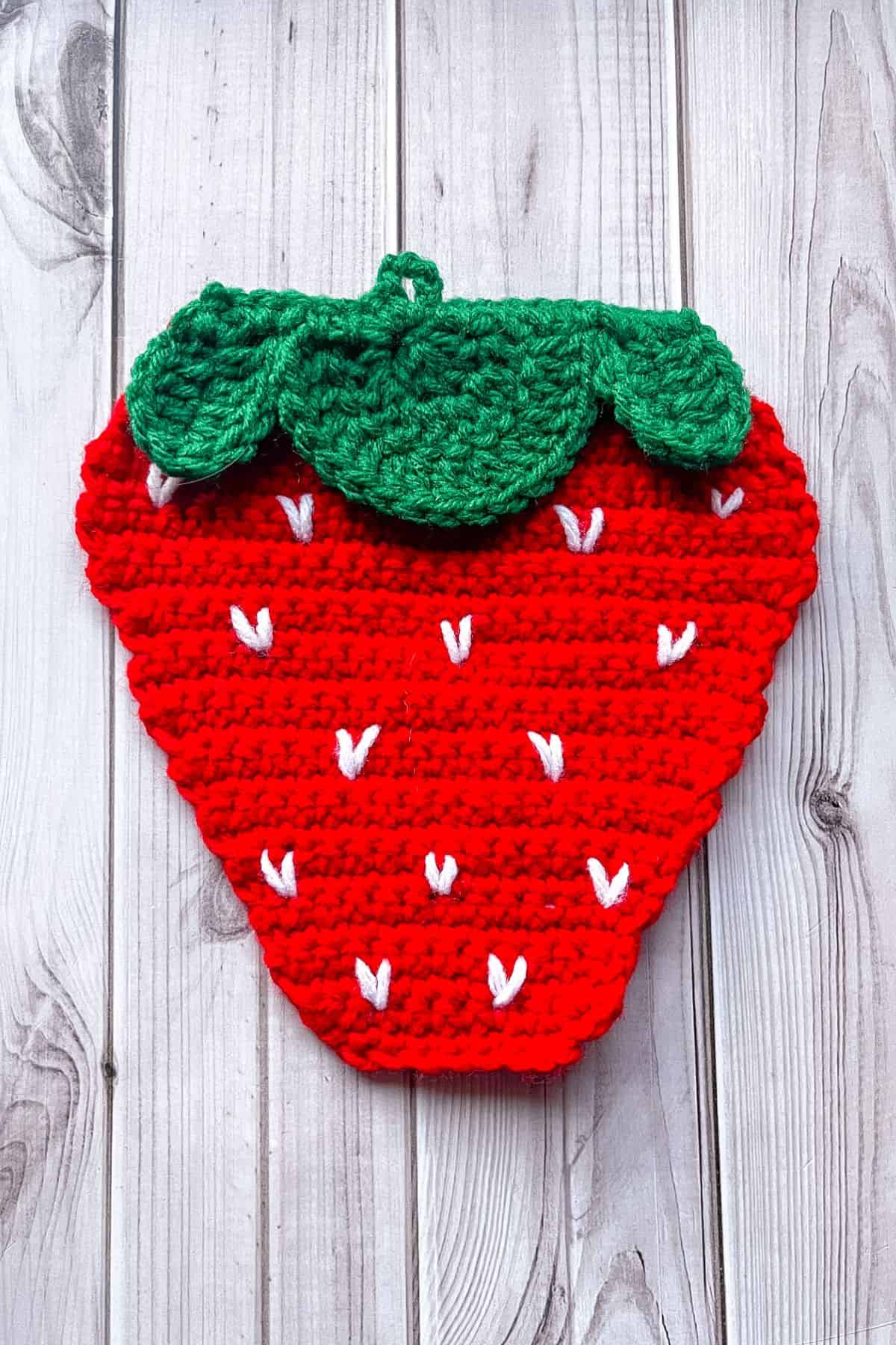 Showing where to embroider the strawberry seeds.