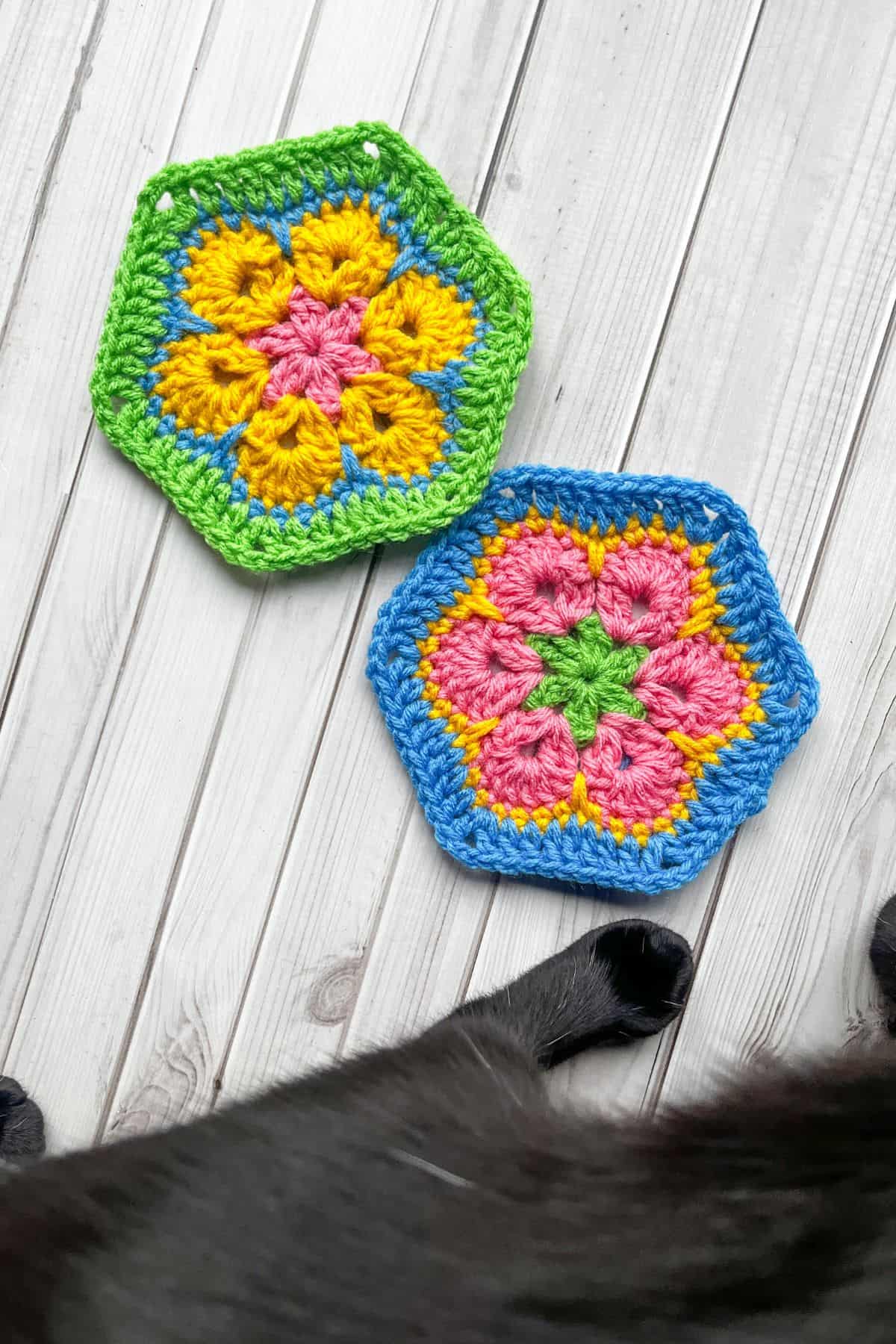 2 finished 6 petal African hexagons on table, with cat.