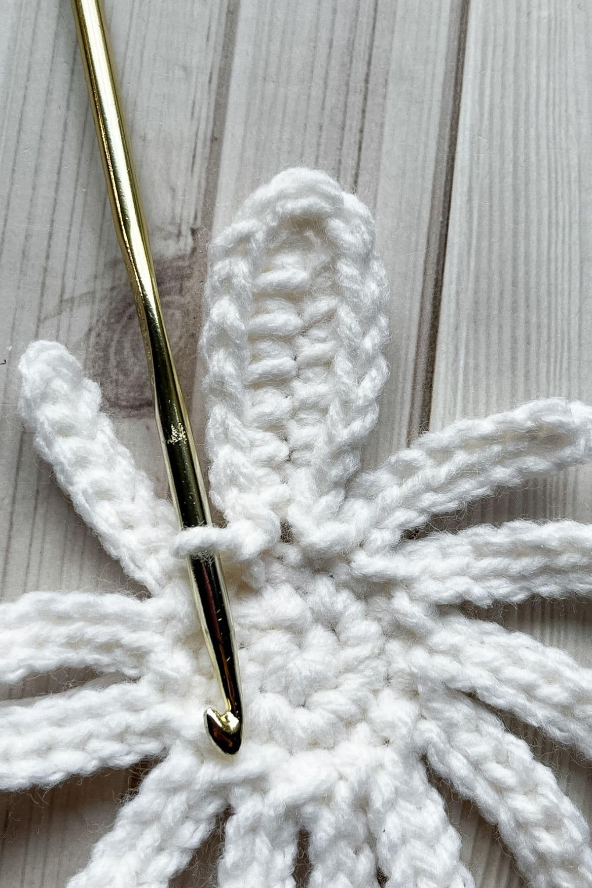 Close up of a finished petal, hook is upside down and laying on the table.