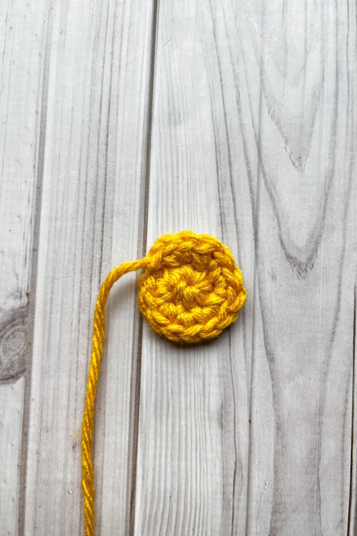 Finished middle of the crochet daisy, laying on the table.