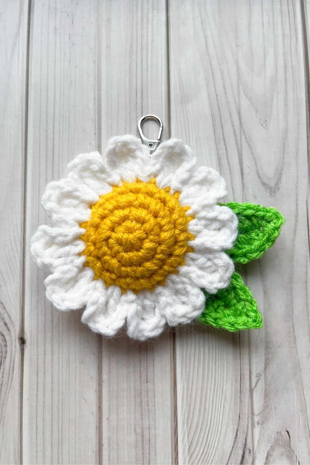1 finished crochet daisy keychains on table.