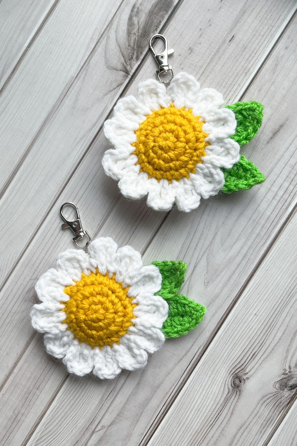 2 finished crochet daisy keychains on table.