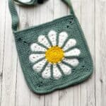 Finished daisy crochet bag pattern on table.