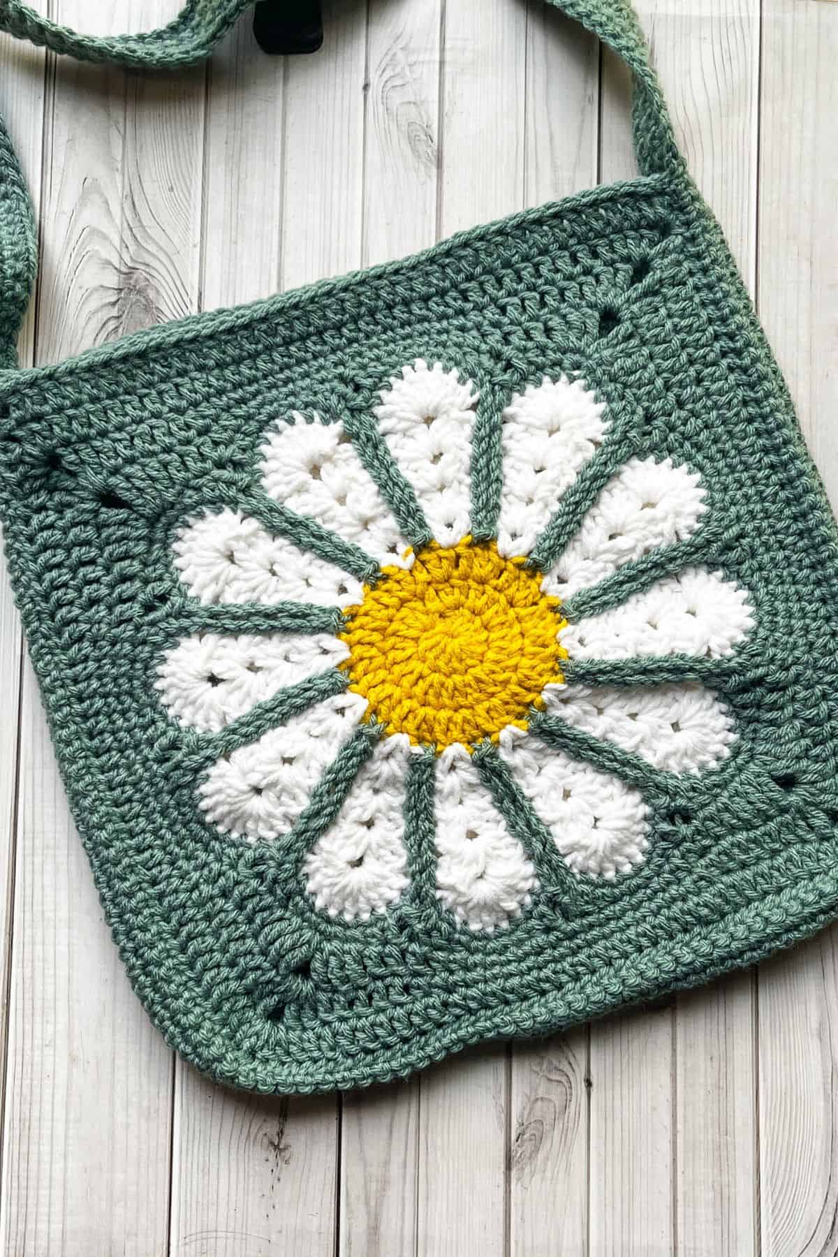 Finished daisy crochet bag pattern on table.