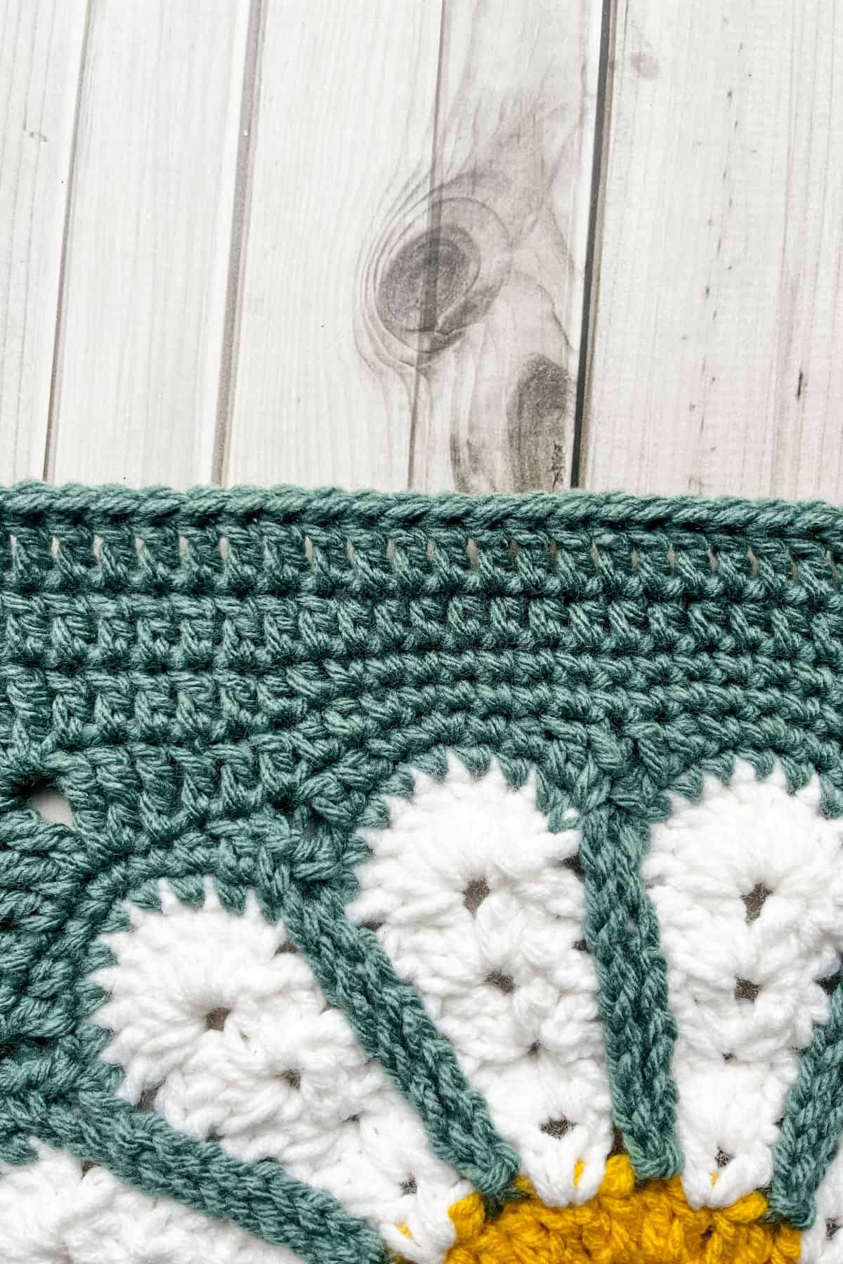 Close up of the row of slip stitches at the top of the daisy crochet bag.
