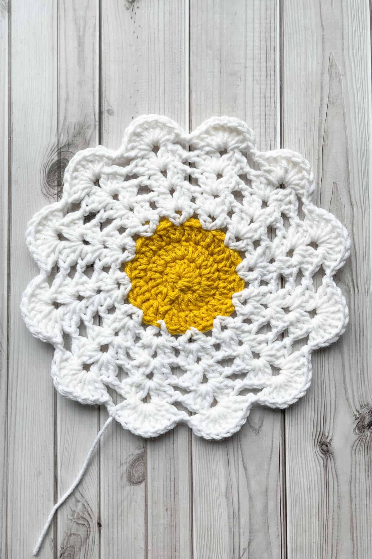 The white part of the daisy pattern is finished and is laying on the table.