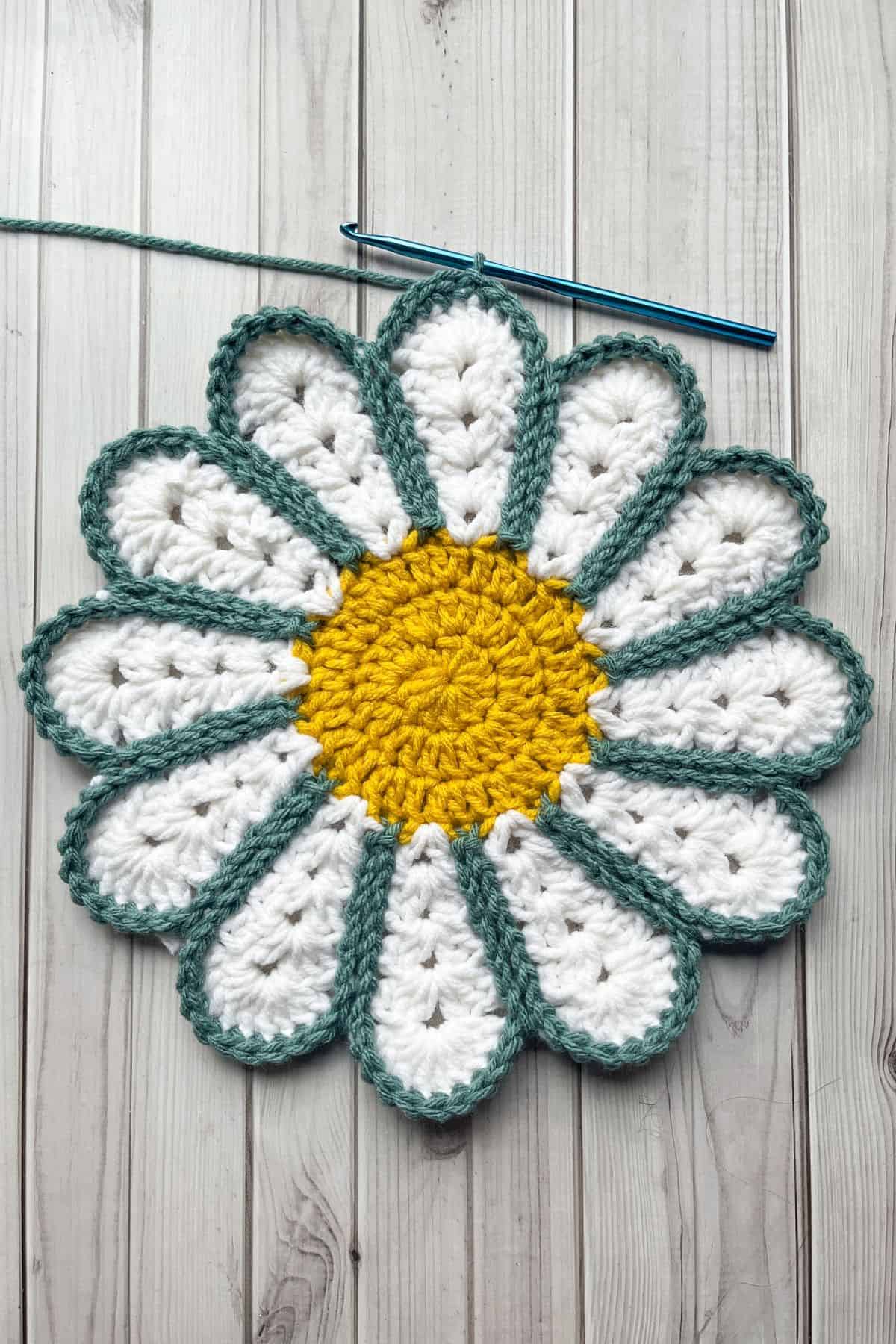 Finished outlining the daisy flower with green yarn.