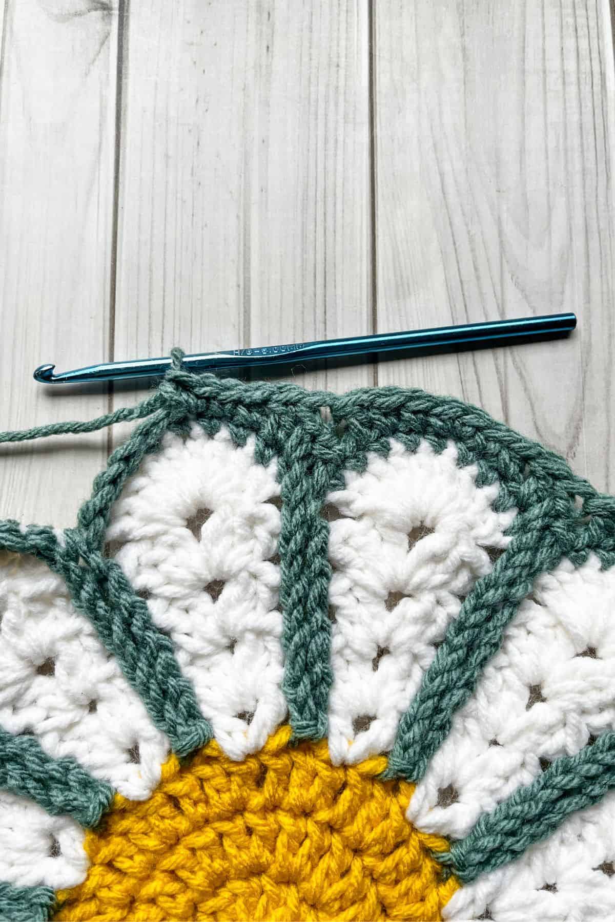 Close up of making the crochet daisy flower into a circle.