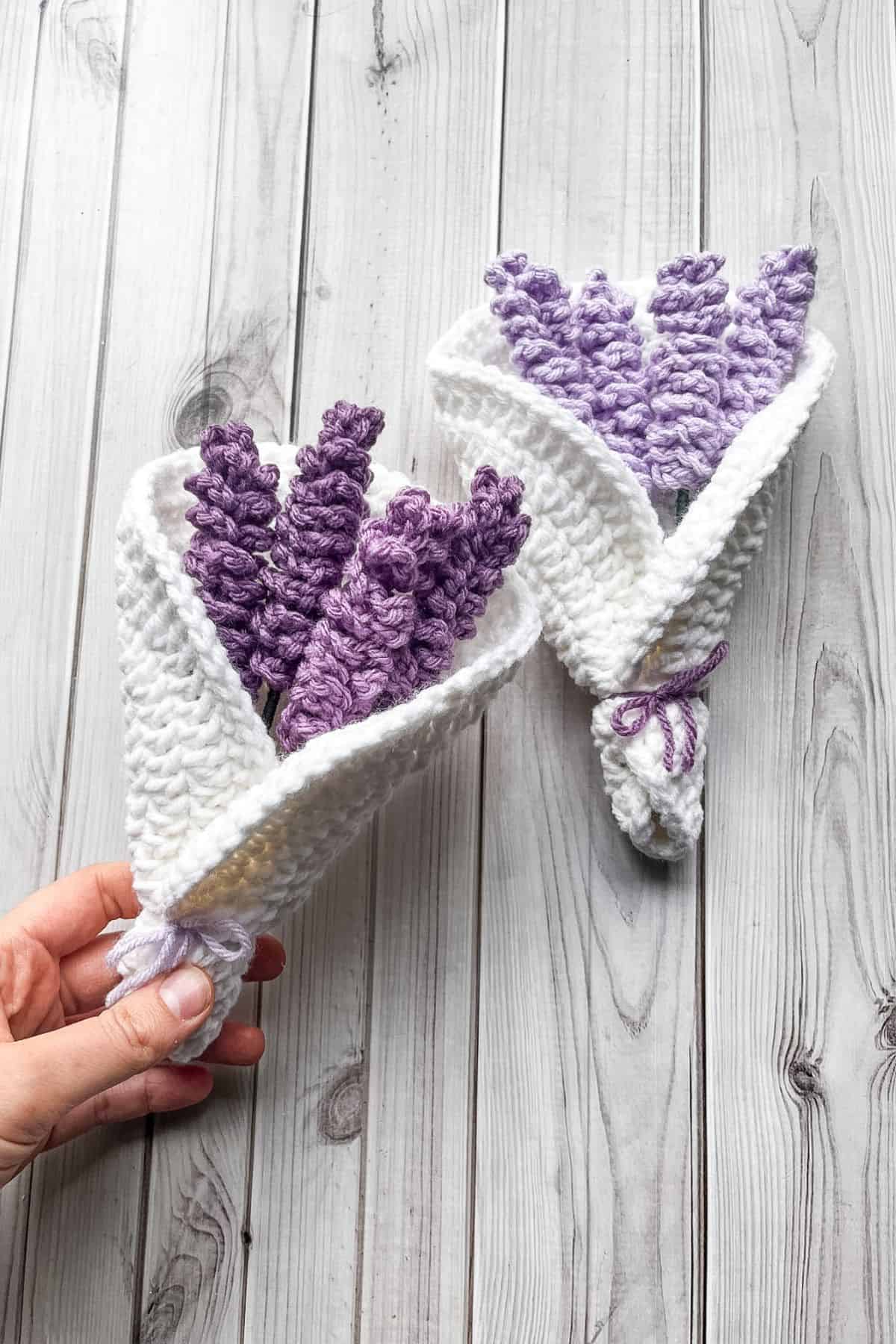 Finished crochet lavender bouquets on table, one in hand.