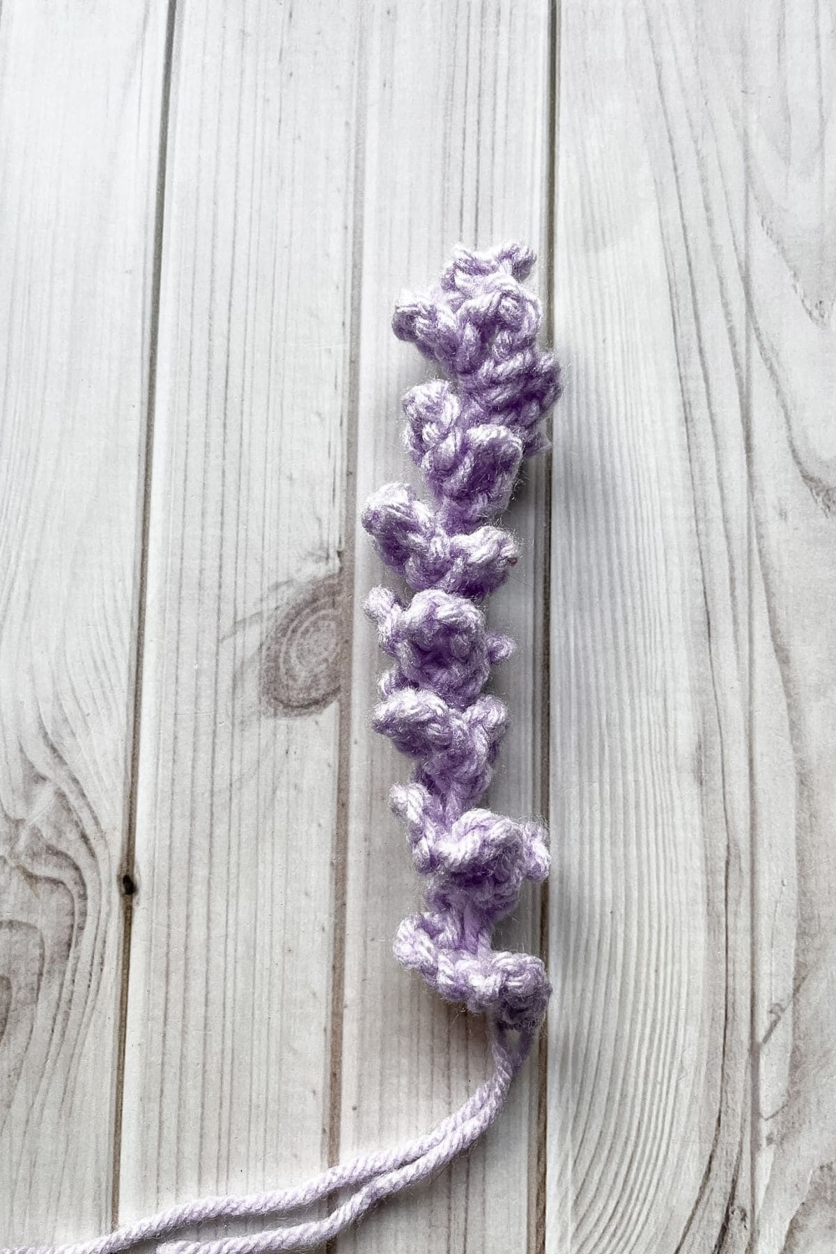 Lavender yarn twist on a light wooden background.