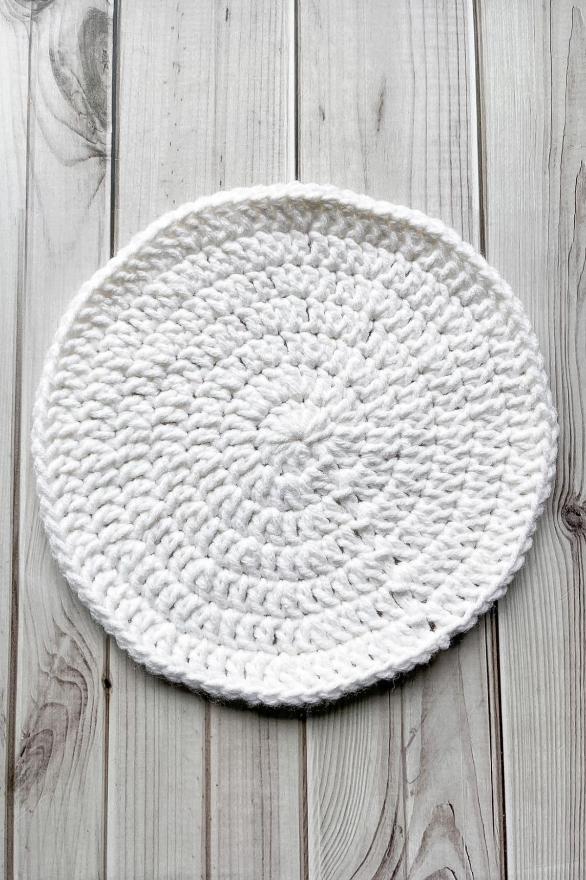 White crochet circle on wooden table.