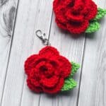 2 finished crochet rose keychains on the table.