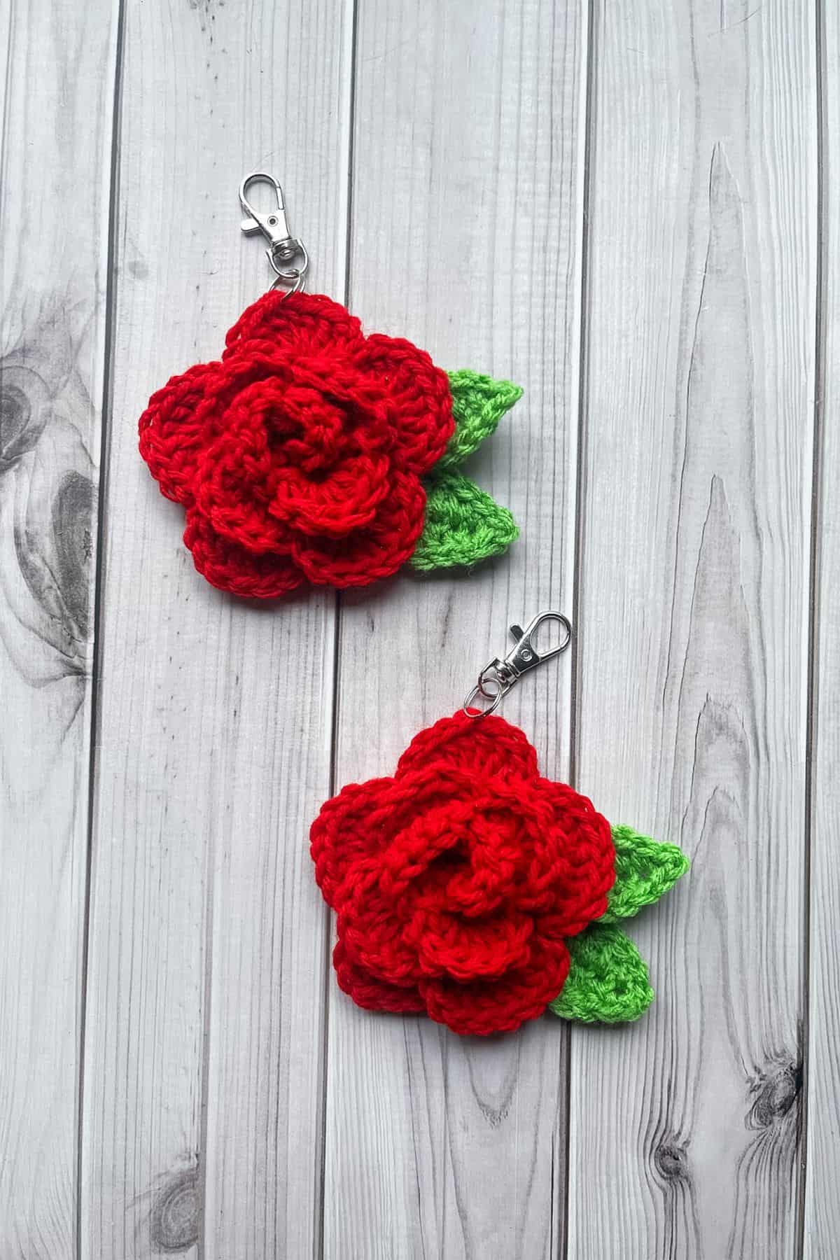 2 finished crochet rose keychains on the table.