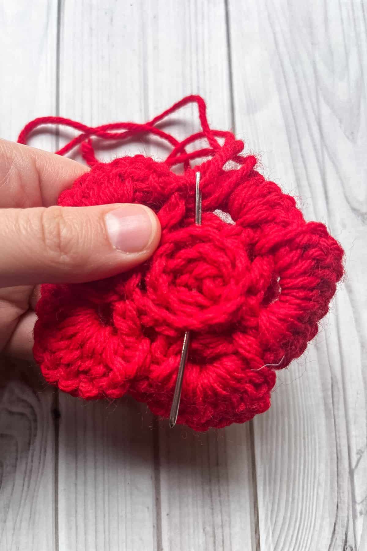 Sewing the crochet rose to secure it.