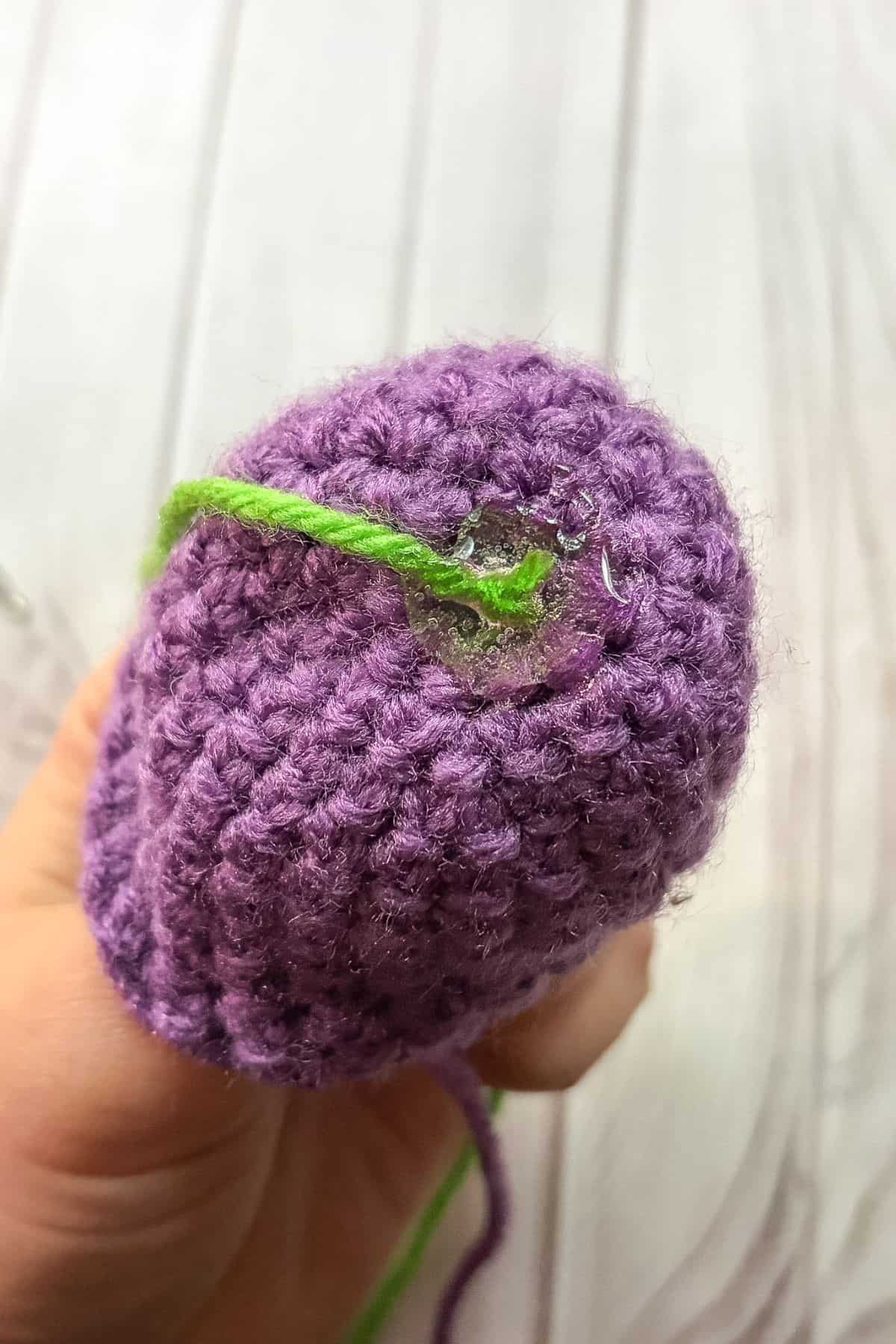 Showing the hot glue dot to secure the wire and yarn.