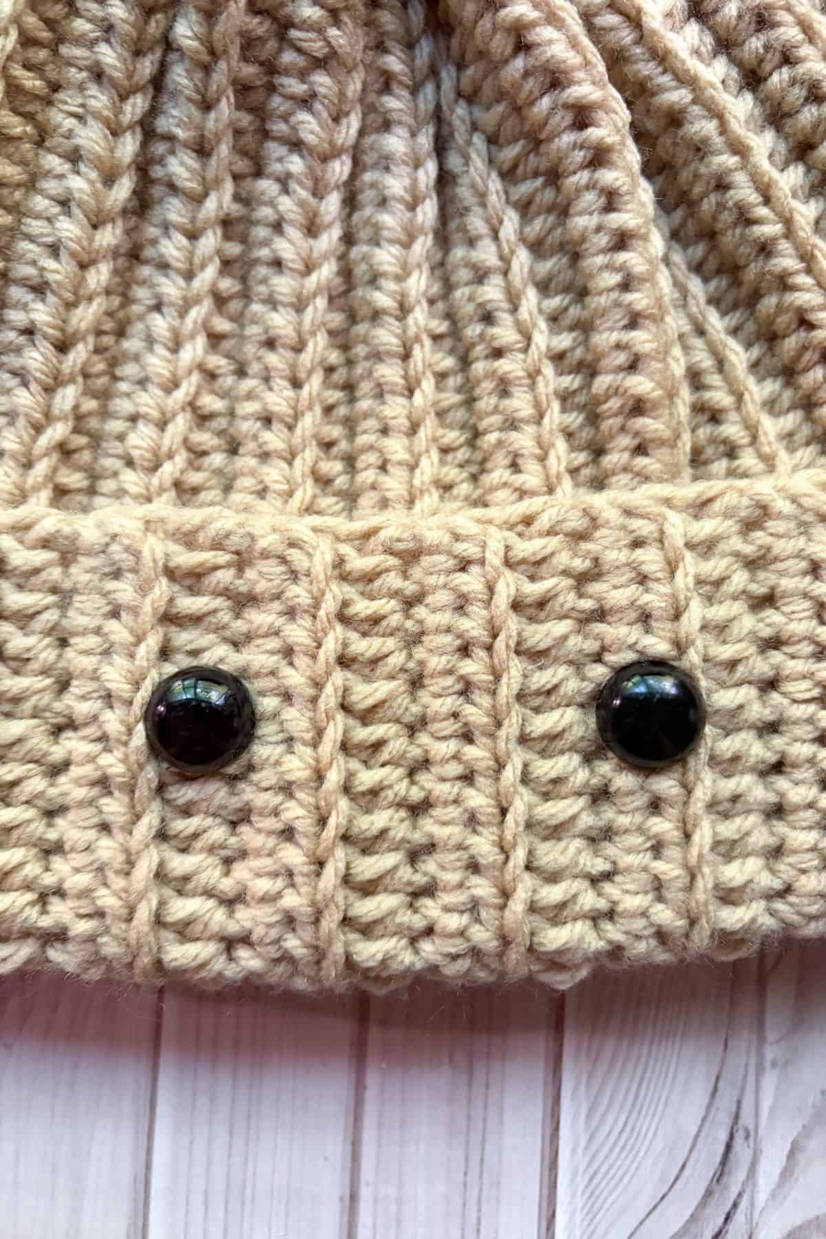 Placing safety eyes onto the hat.