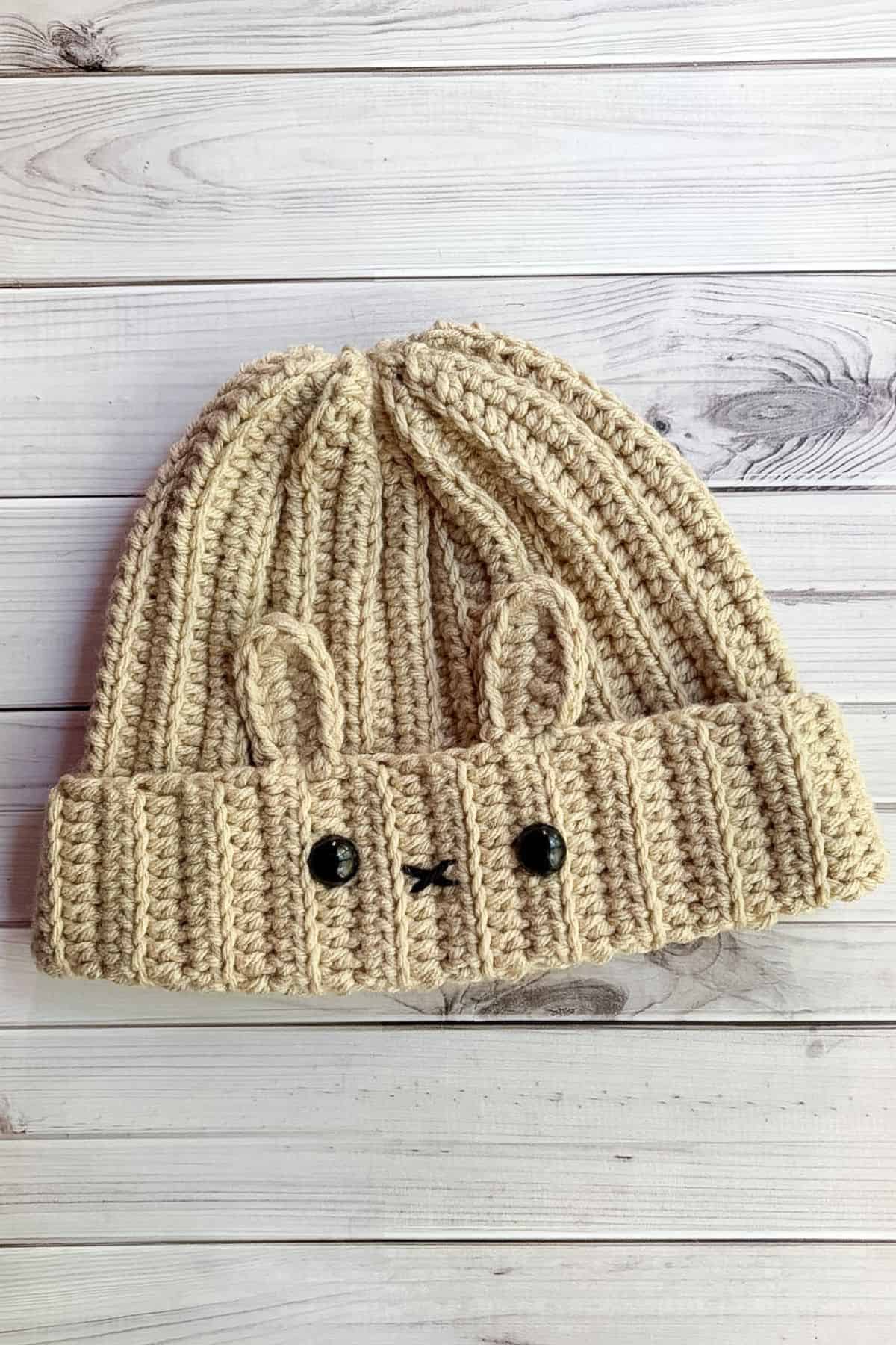 Finished crochet bunny hat on table.
