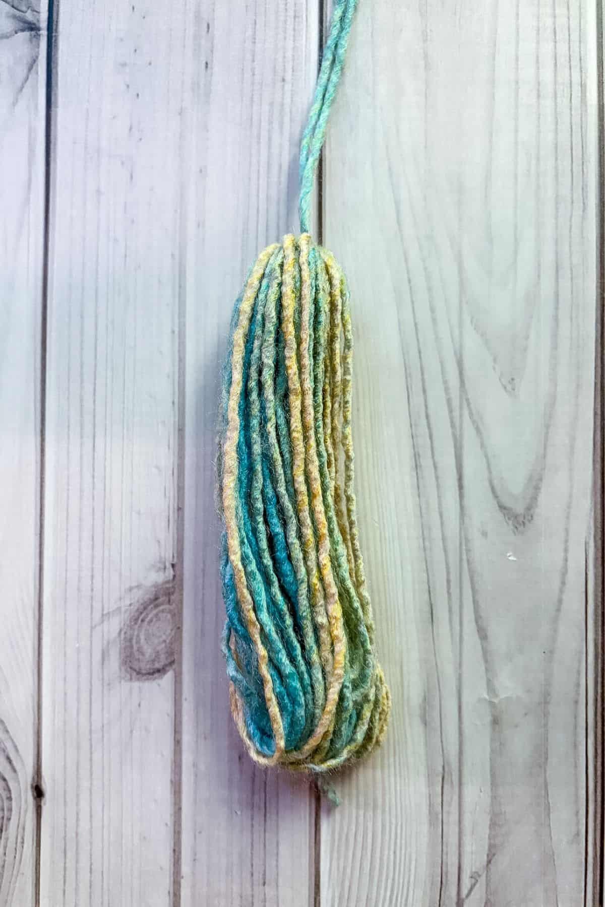 Half-finished tassel on table.
