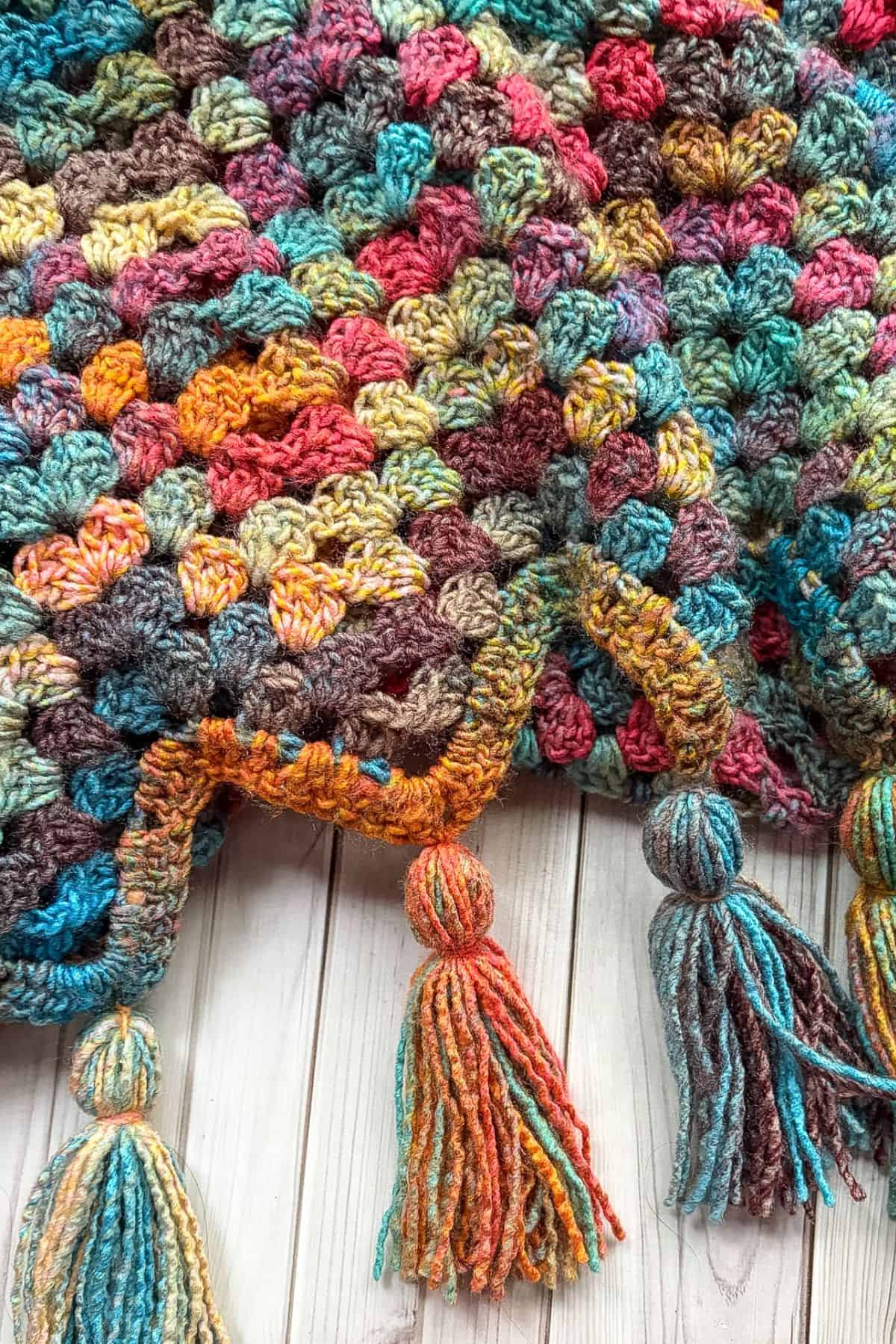 Finished crochet granny ripple blanket with tassels.