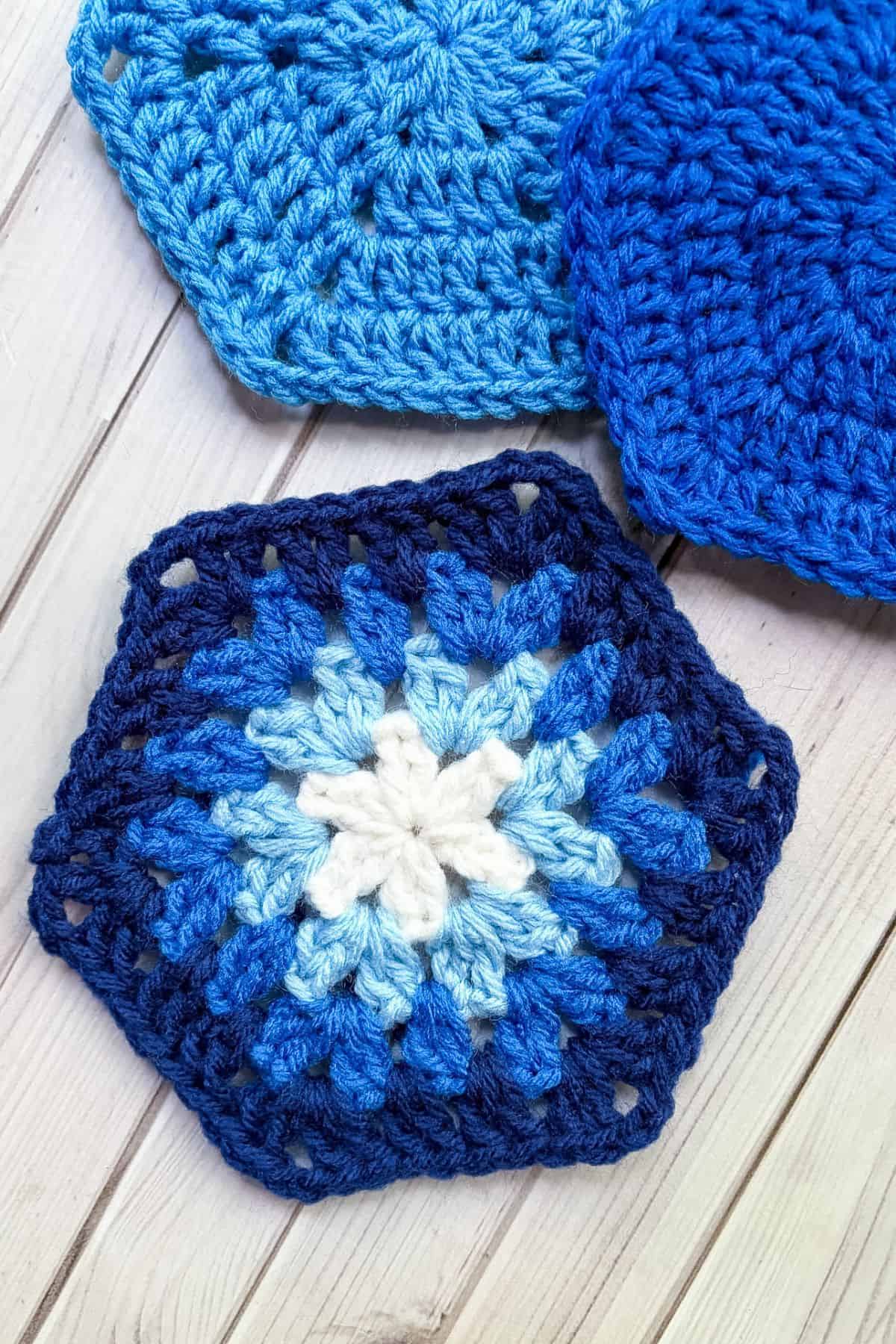 3 finished crochet hexagons on a table.