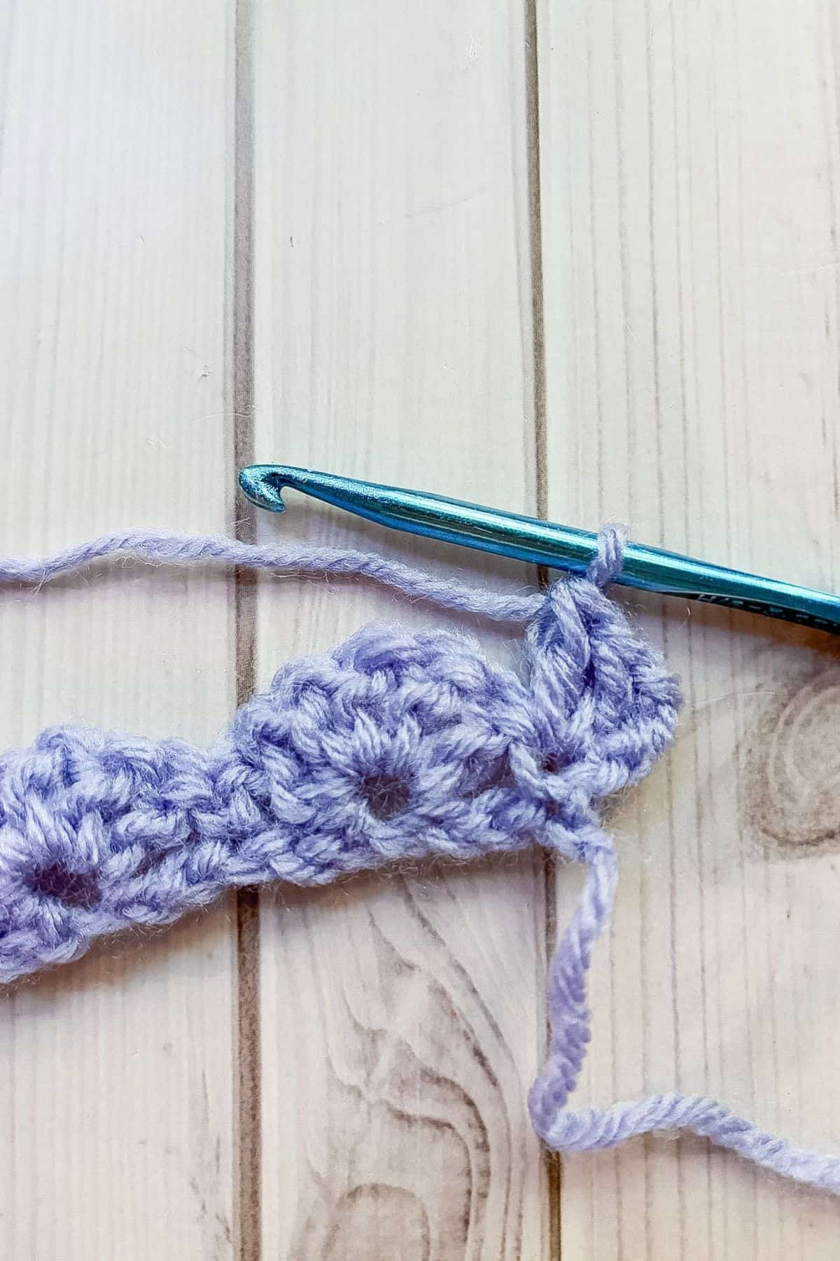 Starting a second row of crochet shell stitches.